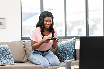 Image showing african american woman with gamepad playing game