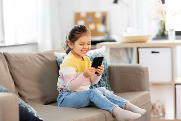 Image showing happy smiling little girl with smartphone at home