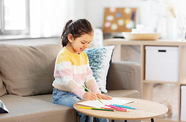 Image showing little girl drawing with coloring pencils at home