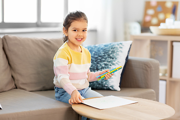 Image showing little girl drawing with coloring pencils at home