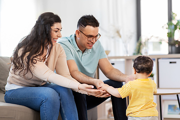 Image showing happy family with child sitting on sofa at home