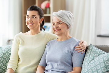 Image showing senior mother with adult daughter hugging at home