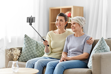 Image showing senior mother with daughter taking selfie at home