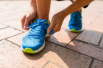 Image showing Woman try to fix shoes lace at outdoor