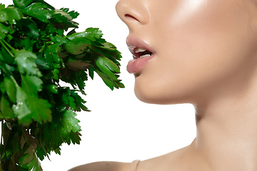 Image showing Fresh. Close up of beautiful young woman with green leaves over white background. Cosmetics and makeup, natural and eco treatment, skin care