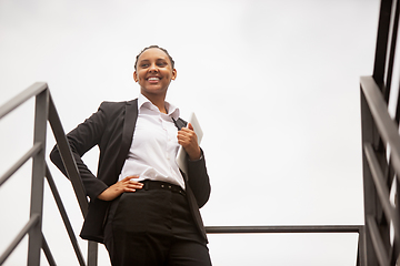 Image showing African-american businesswoman in office attire smiling, looks confident and happy, successful