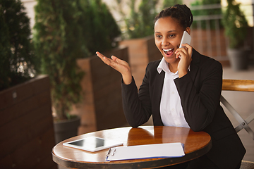 Image showing African-american businesswoman in office attire smiling, looks confident and happy, successful