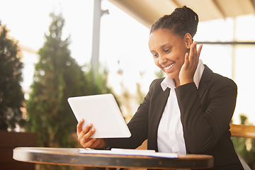 Image showing African-american businesswoman in office attire smiling, looks confident and happy, successful