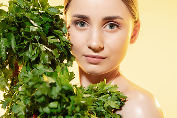 Image showing Fresh. Close up of beautiful female face with green leaves over white background. Cosmetics and makeup, natural and eco treatment, skin care.