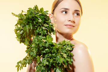 Image showing Fresh. Close up of beautiful female face with green leaves over white background. Cosmetics and makeup, natural and eco treatment, skin care.