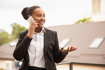 Image showing African-american businesswoman in office attire smiling, looks confident and happy, successful