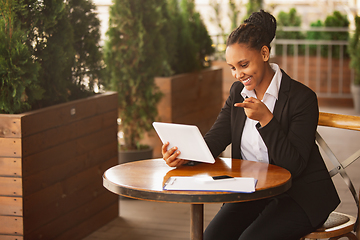 Image showing African-american businesswoman in office attire smiling, looks confident and happy, successful