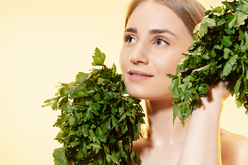 Image showing Fresh. Close up of beautiful female face with green leaves over white background. Cosmetics and makeup, natural and eco treatment, skin care.