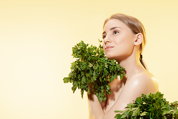 Image showing Fresh. Close up of beautiful female face with green leaves over white background. Cosmetics and makeup, natural and eco treatment, skin care.