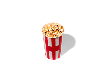 Image showing Striped white red bucket full of popcorn isolated on white studio background with copyspace