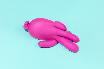 Image showing Life of rubber glove like a person - protective wear isolated on blue studio background