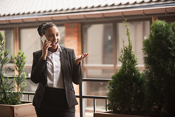 Image showing African-american businesswoman in office attire smiling, looks confident and happy, successful