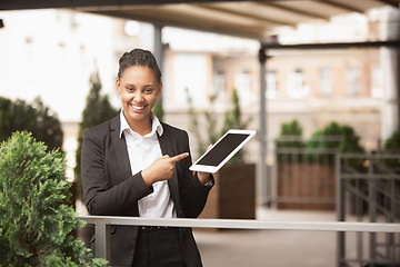 Image showing African-american businesswoman in office attire smiling, looks confident and happy, successful