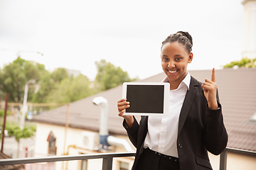 Image showing African-american businesswoman in office attire smiling, looks confident and happy, successful