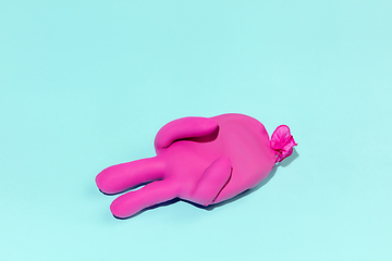 Image showing Life of rubber glove like a person - protective wear isolated on blue studio background