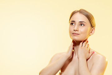 Image showing Tender skin. Close up of beautiful woman with moisturizer over yellow background. Cosmetics and makeup, natural and eco treatment, skin care.