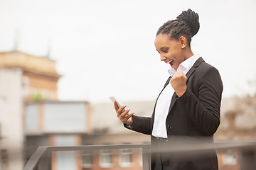 Image showing African-american businesswoman in office attire smiling, looks confident and happy, successful