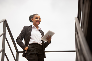 Image showing African-american businesswoman in office attire smiling, looks confident and happy, successful