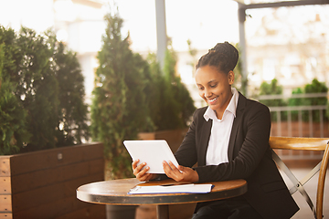 Image showing African-american businesswoman in office attire smiling, looks confident and happy, successful