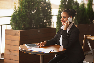 Image showing African-american businesswoman in office attire smiling, looks confident and happy, successful