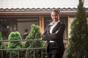 Image showing African-american businesswoman in office attire smiling, looks confident and happy, successful