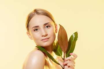 Image showing Feminine. Close up of beautiful female face with green leaves over white background. Cosmetics and makeup, natural and eco treatment, skin care.