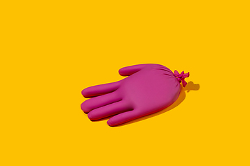 Image showing Life of rubber glove like a person - protective wear isolated on yellow studio background