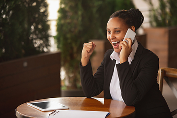 Image showing African-american businesswoman in office attire smiling, looks confident and happy, successful