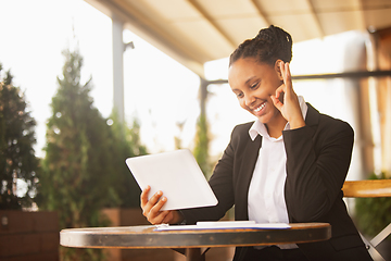 Image showing African-american businesswoman in office attire smiling, looks confident and happy, successful