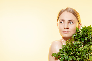 Image showing Fresh. Close up of beautiful female face with green leaves over white background. Cosmetics and makeup, natural and eco treatment, skin care.