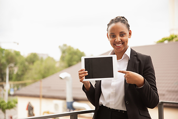 Image showing African-american businesswoman in office attire smiling, looks confident and happy, successful