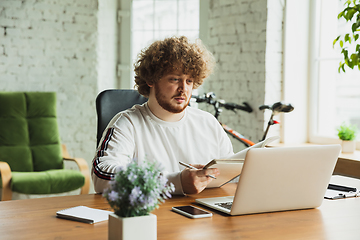 Image showing Manager or student working from home while being insulated or keep quarantine \'cause of coronavirus COVID-19. Making notes.