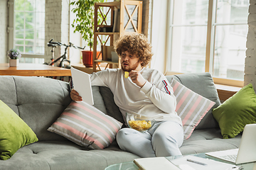 Image showing Manager or student working from home while being insulated or keep quarantine \'cause of coronavirus COVID-19. Reading report, task, sitting on sofa.