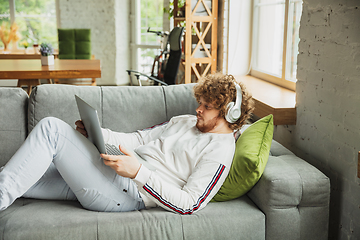 Image showing Manager or student working from home while being insulated or keep quarantine \'cause of coronavirus COVID-19. Working lying down on sofa.