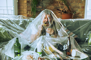 Image showing Senior man covered with plastic, eating fast food and drinking beer - environmental pollution by people concept