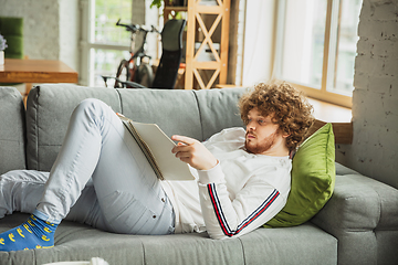 Image showing Manager or student working from home while being insulated or keep quarantine \'cause of coronavirus COVID-19. Working lying down on sofa.