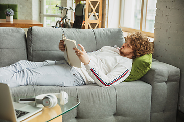 Image showing Manager or student working from home while being insulated or keep quarantine \'cause of coronavirus COVID-19. Working lying down on sofa.