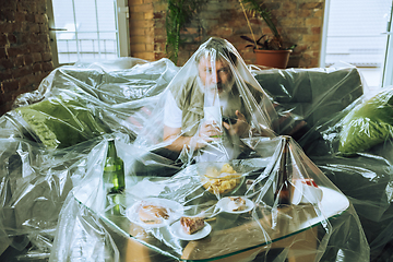 Image showing Senior man covered with plastic, eating fast food and drinking beer - environmental pollution by people concept