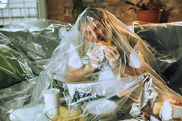 Image showing Senior man covered with plastic, eating fast food and drinking beer - environmental pollution by people concept