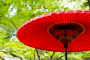 Image showing Red paper umbrella in park