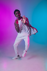 Image showing African-american male singer portrait isolated on gradient studio background in neon light