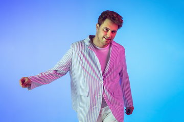 Image showing Young caucasian musician, dancer, party host, DJ on gradient background in neon light