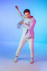 Image showing Young caucasian musician, dancer, party host, DJ on gradient background in neon light