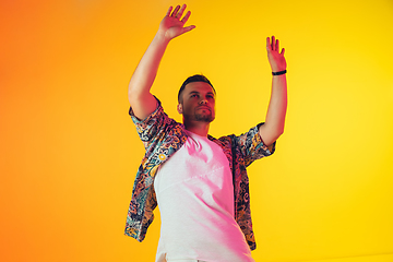 Image showing Young caucasian musician, dancer, party host, DJ on gradient background in neon light