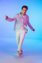 Image showing Young caucasian musician, dancer, party host, DJ on gradient background in neon light